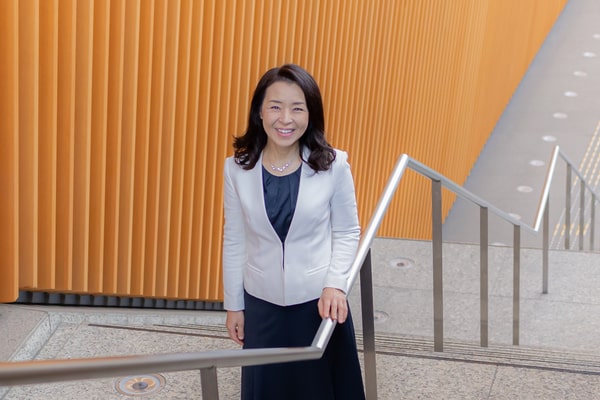 階段を登りながら微笑む女性