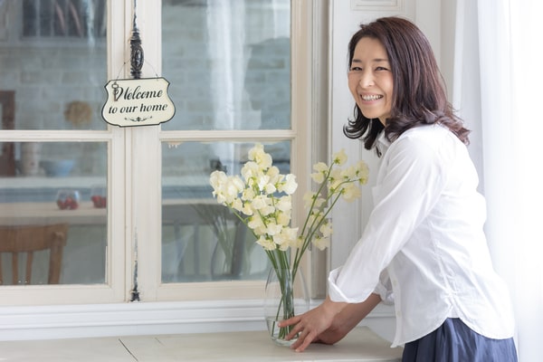 生花をバックに微笑む女性