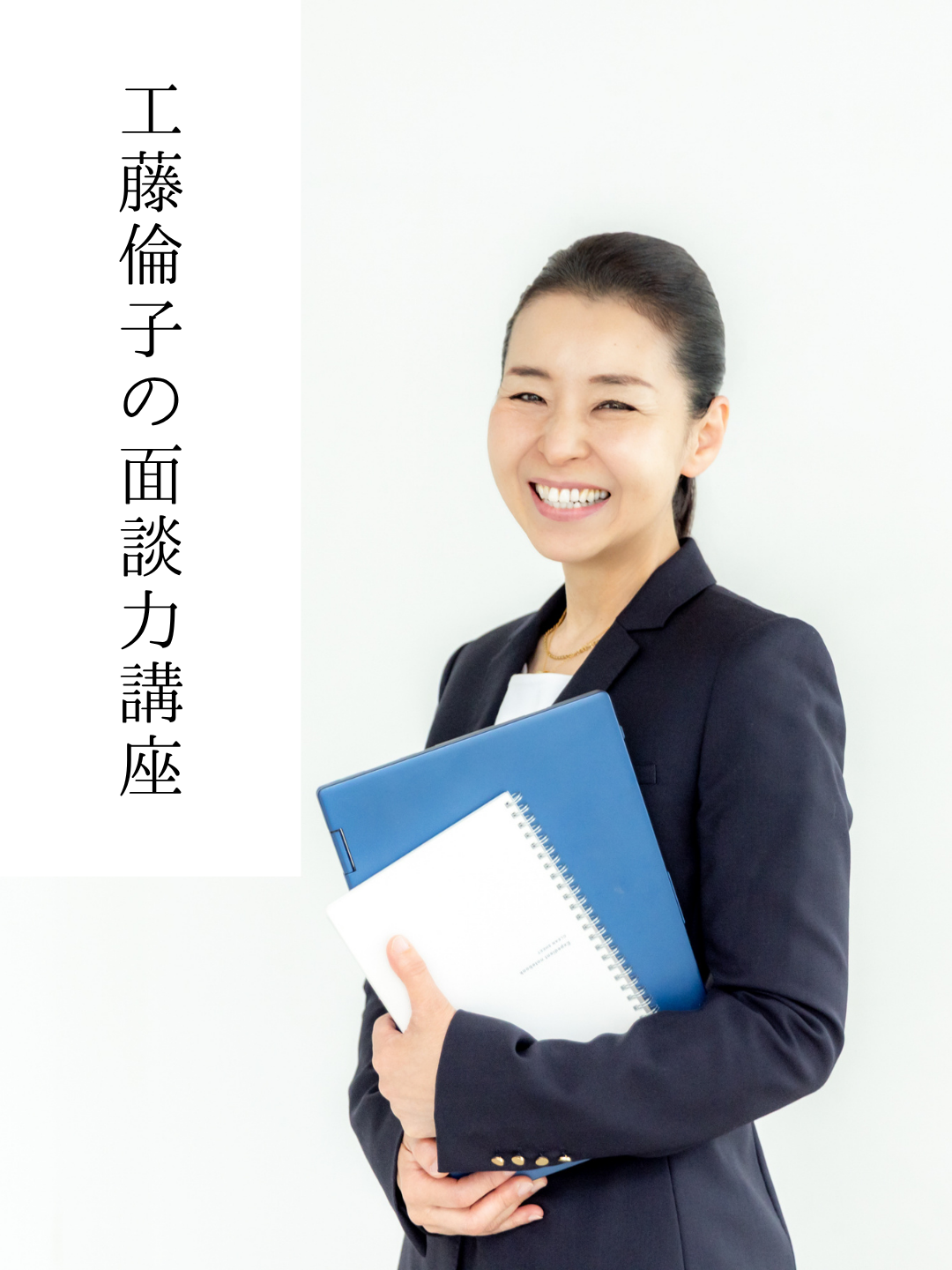 ファイルケースを持って立つスーツ姿の工藤倫子